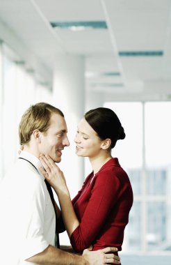 Ofis koridorunda sarılan iki yönetici.