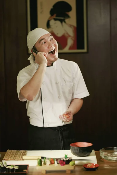 Szef Kuchni Rozmawia Przez Telefon Podczas Przygotowywania Posiłków — Zdjęcie stockowe