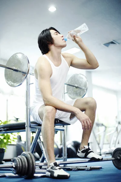 Hombre Sentado Gimnasio Bebiendo Agua Embotellada —  Fotos de Stock