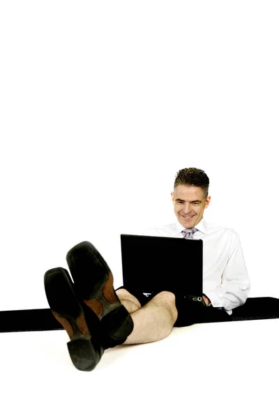 商人使用笔记本电脑时 两条腿放在桌子上 — 图库照片