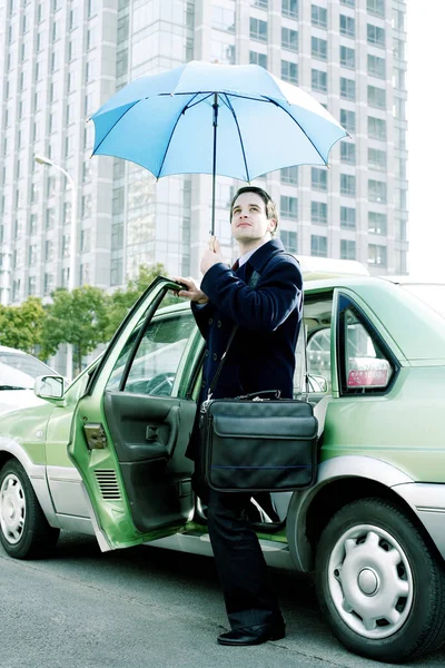 Empresário Segurando Guarda Chuva Enquanto Sai Táxi — Fotografia de Stock