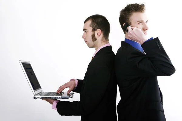 Businessmen Talking Cell Phone Using Laptop Stock Picture