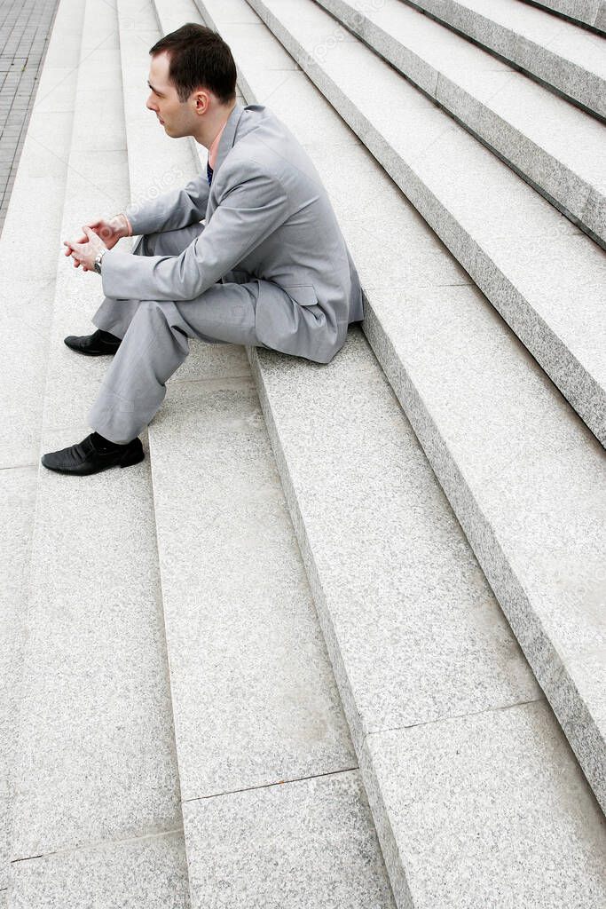 Businessman sitting on the stairs thinking