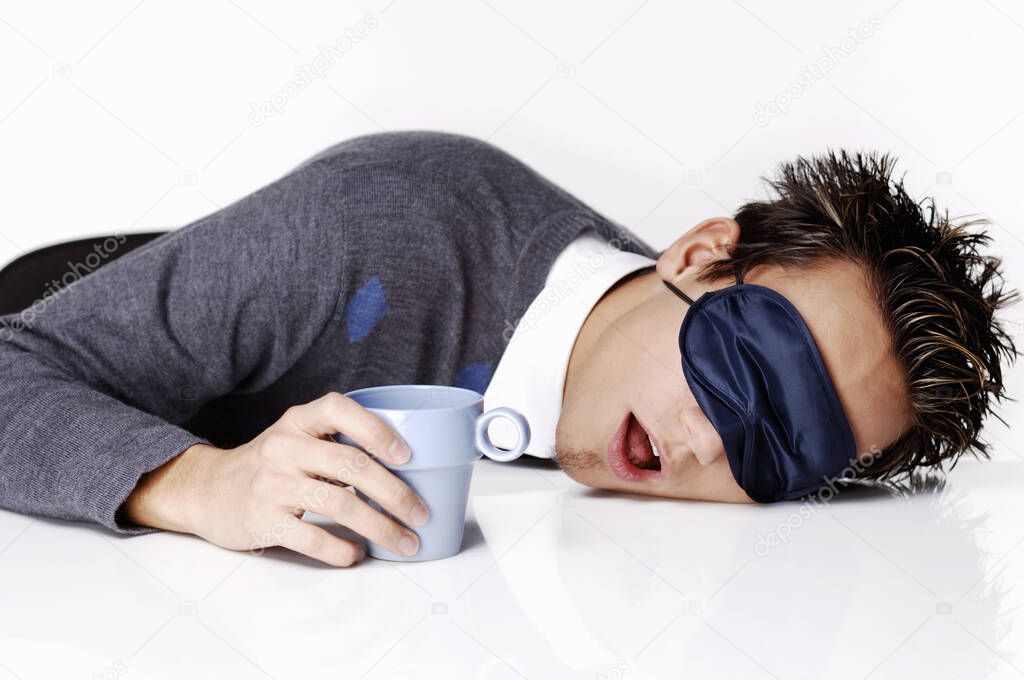 Man with eye mask sleeping with the head on the table