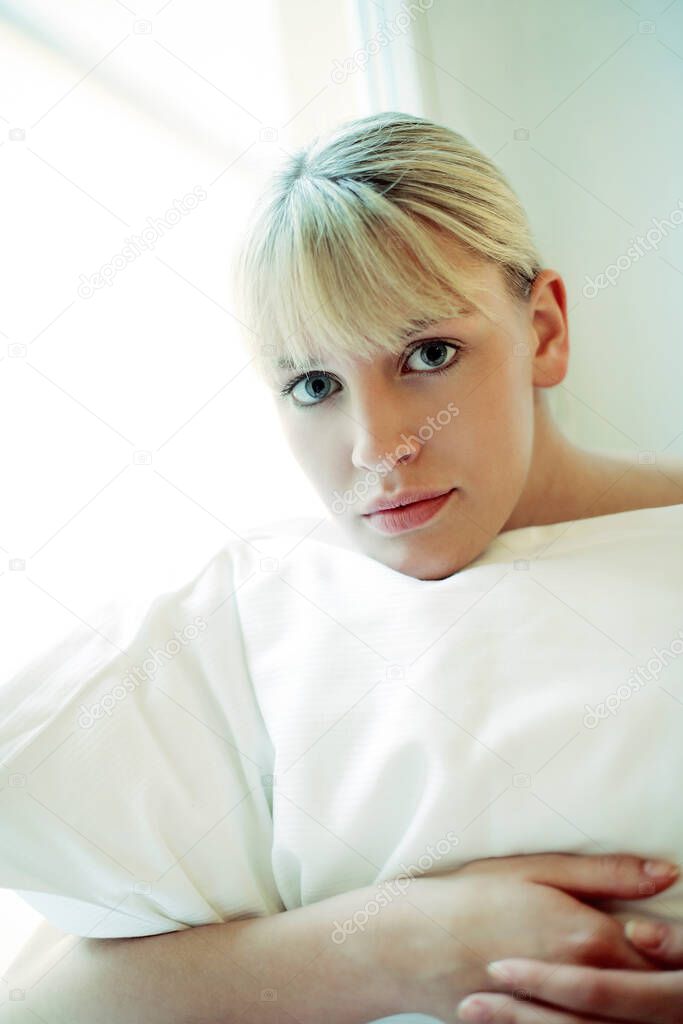Woman hugging her pillow while looking at the camera