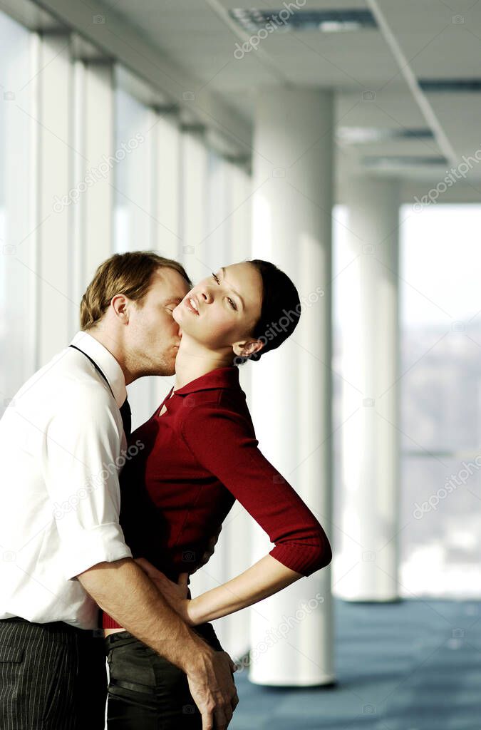 Businessman hugging and kissing businesswoman