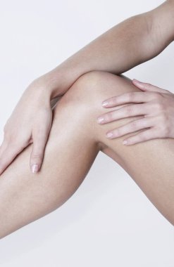 Kadın bacağına dokunuyor.