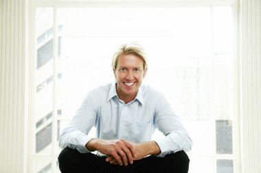 İş adamı gülümsüyor ve kameraya bakıyor.