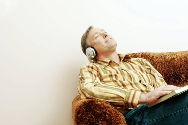 Kitap okurken müzik dinleyen adam