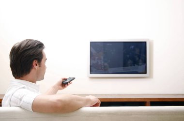 Uzaktan kumandayla televizyonu kontrol eden adam