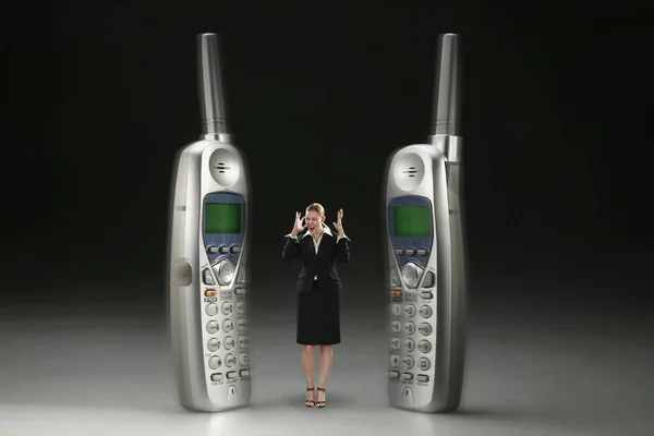 Geschäftsfrau Steht Zwischen Zwei Klingelnden Telefonen — Stockfoto