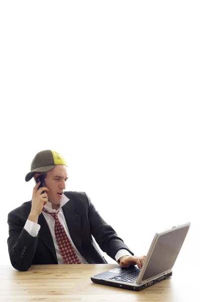时髦的商人一边用手提电脑一边用手机聊天 — 图库照片