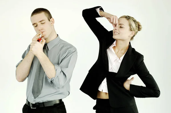 Businesswoman Pinching Her Nose While Businessman Smoking — Stockfoto