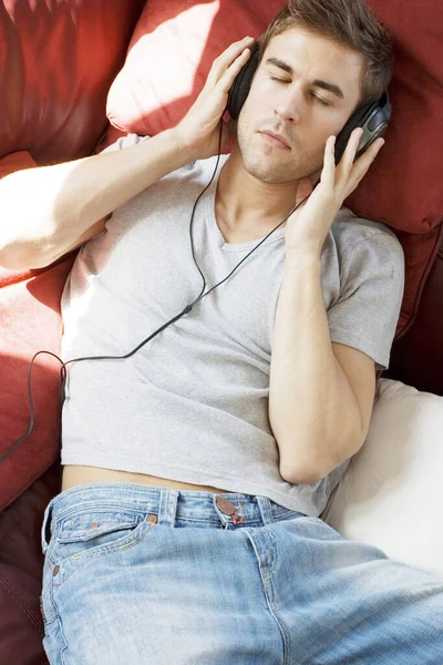 Mann Liegt Auf Dem Bett Und Hört Musik Über Kopfhörer — Stockfoto