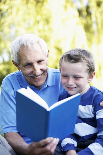 祖父と孫が本をシェアする — ストック写真