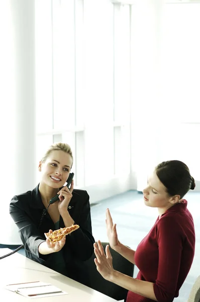 Businesswoman Offering Her Colleague Slice Pizza While Talking Phone — Stock Photo, Image