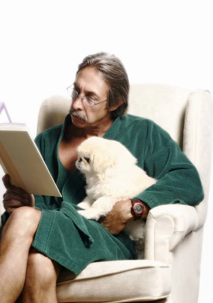 Senior Man Knuffelen Zijn Hond Terwijl Het Lezen Van Boek — Stockfoto