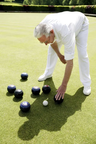 Hombre Agachándose Para Recoger Bolas Bolos —  Fotos de Stock