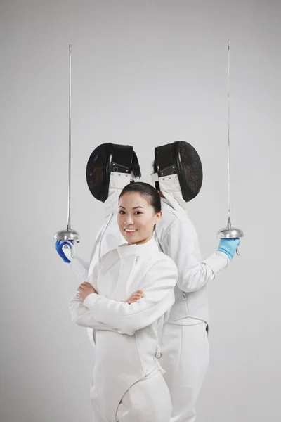 Woman and two men in fencing suits posing for the camera