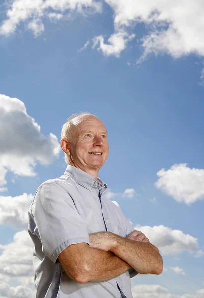 Hombre Mayor Sonriendo Mientras Dobla Los Brazos — Foto de Stock