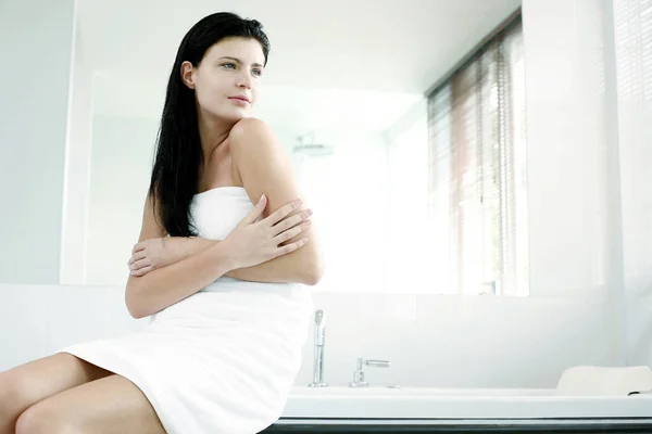 裹着毛巾坐在浴缸上的女人 — 图库照片