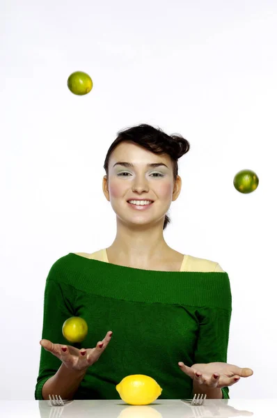 Woman Juggling Three Limes — Stockfoto