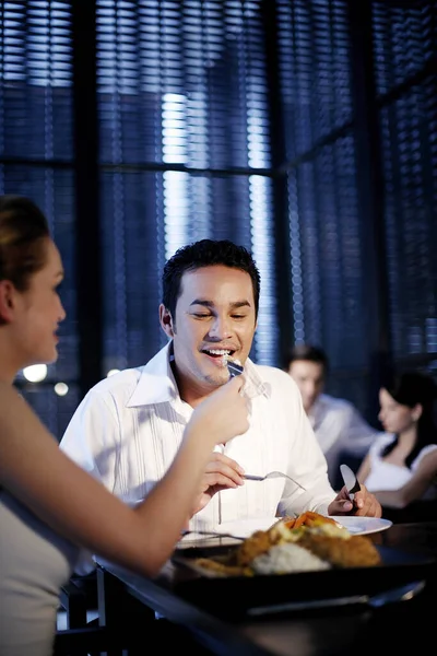 レストランで食事をしながら彼氏に食事をする女 — ストック写真