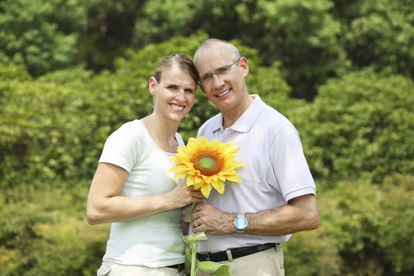 Husband and wife holding a sunflower