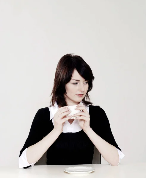 Businesswoman thinking while holding a cup of coffee