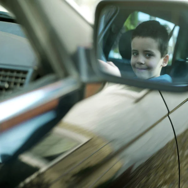坐在车上的男孩的侧镜反射 — 图库照片