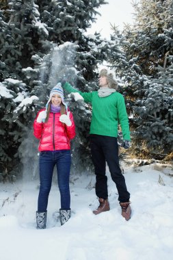 Ağaç çeken bir adam, kadının üzerine düşen bir kar.