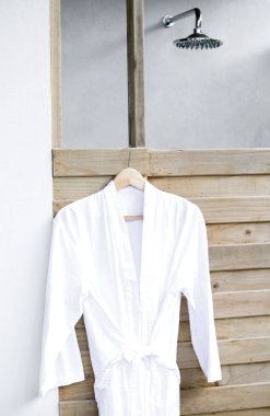 Banyonun dışında beyaz bornoz asılı.