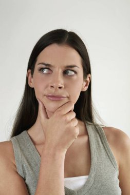 Kadın düşünürken çenesine dokunuyor.