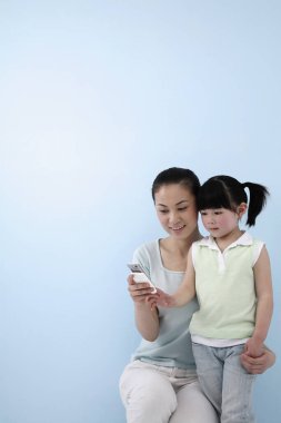 Cep telefonunda kız fotoğrafı gösteren bir kadın.