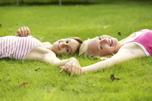 Tonårstjejer Som Håller Händer När Ligger Planen — Stockfoto