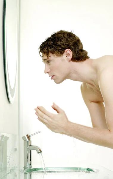 浴室で顔を洗う男 — ストック写真