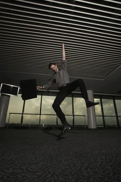 ビジネスマンは空港ラウンジで育った拳でジャンプします — ストック写真