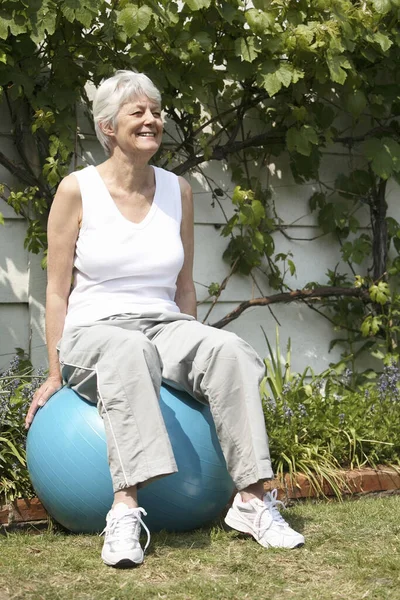 Senior woman sitting on fitness ball