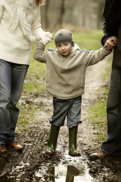 Boy Holding Parents Hands — Stockfoto