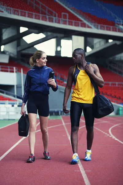 Man and woman chatting while walking on track