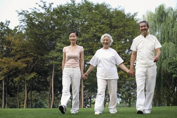 Frau Zusammen Mit Senioren Paar Beim Spaziergang Park Händchen Haltend — Stockfoto