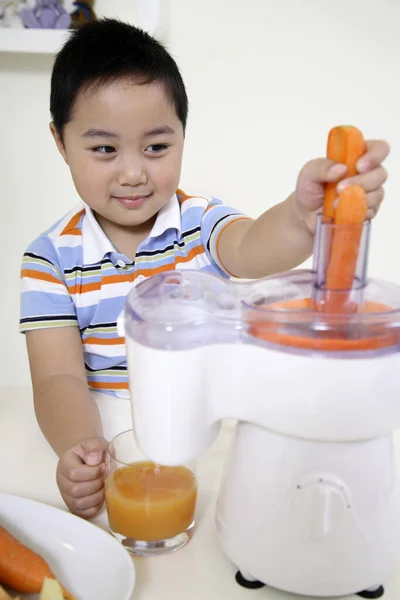Boy Putting Carrots Juicer — Stock Photo, Image