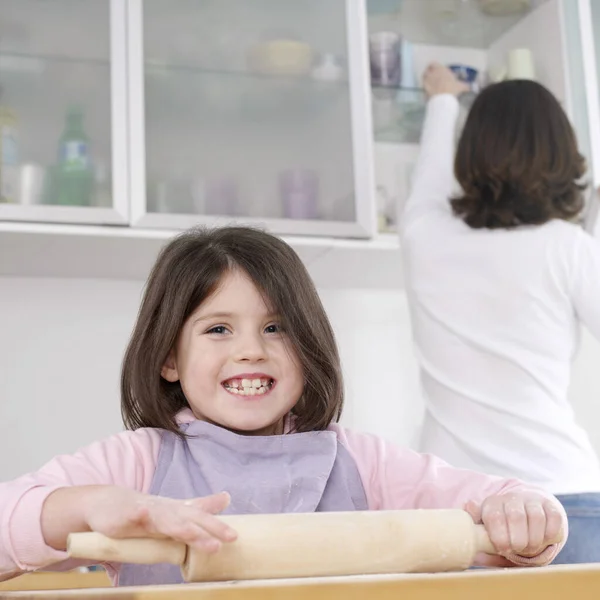 Girl Using Rolling Pin Her Mother Background — Stock Photo, Image