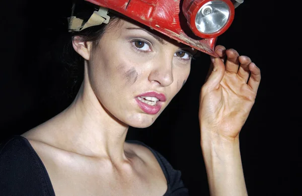 Woman with dirty face wearing a safety helmet