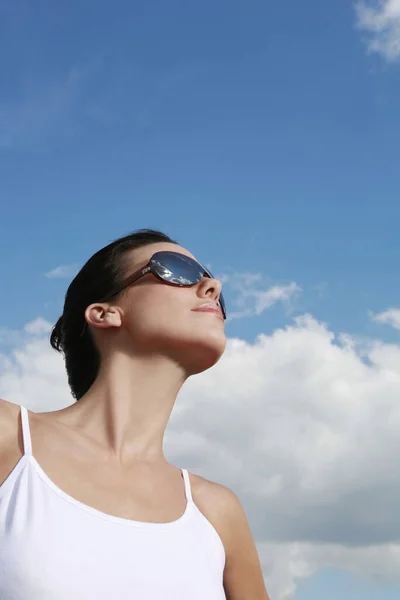 Güneş Gözlüklü Genç Kadın Gökyüzüne Karşı — Stok fotoğraf