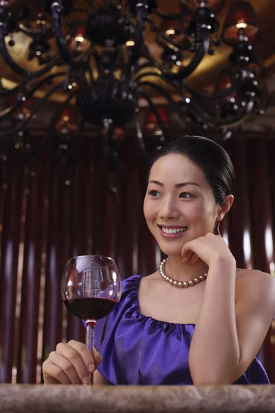 Woman holding a glass of wine smiling