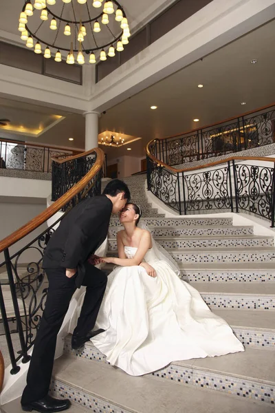 階段の上で室内でポーズをとる新郎新婦 — ストック写真