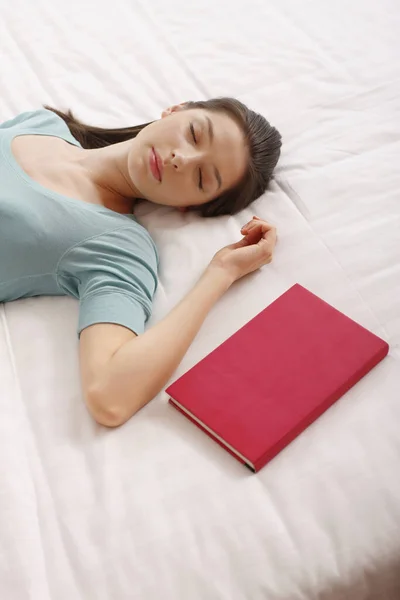 Wanita Berbaring Tempat Tidur Dengan Mata Tertutup Buku Sampingnya — Stok Foto