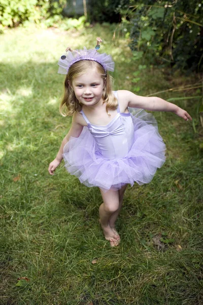 Little girl wearing ballet dress dancing happily