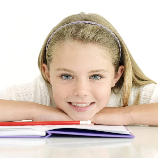 Girl Smiling Camera While Resting Her Chin Book — Stock Photo, Image